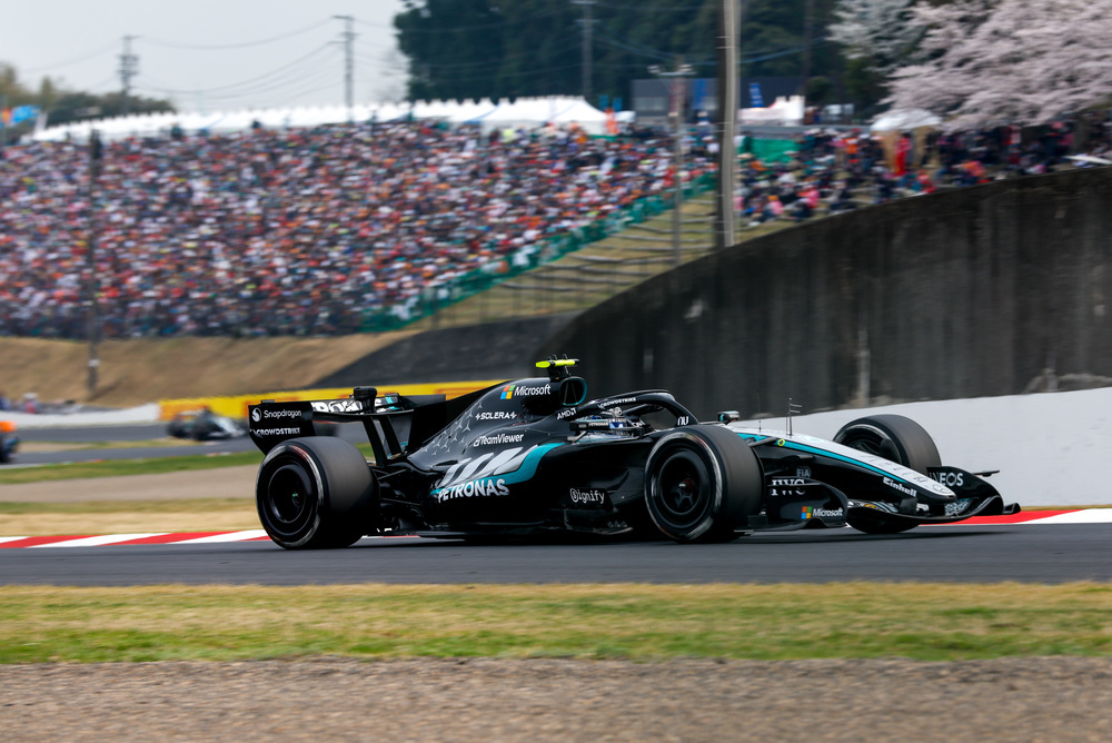 Coche F1 Mercedes pasando frente a gradas llenas de aficionados