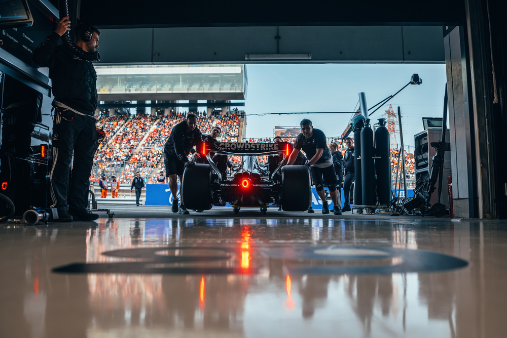 Coche F1 Mercedes en el garaje con equipo y luces