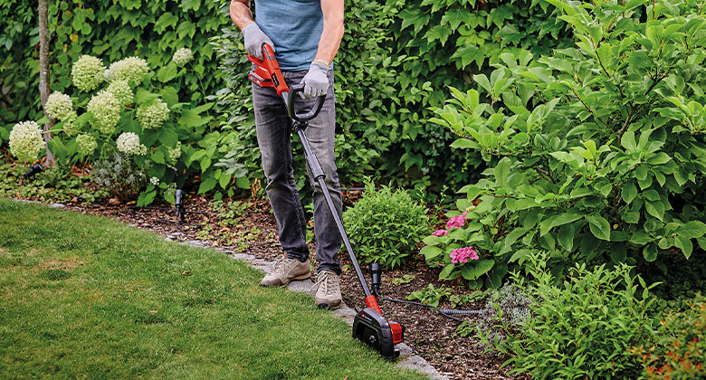 a man is edging the gras with the Einhell Cordless Lawn Edge Trimmer