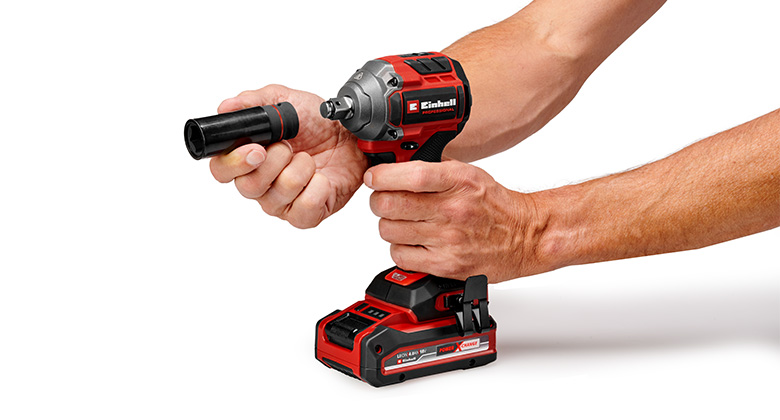 A person attaches a socket to a cordless impact wrench.