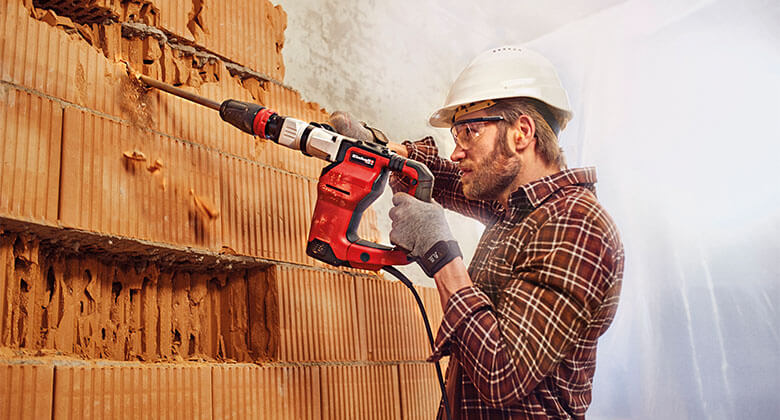 A man working with an electric rotary hammer