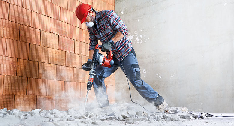 man destroying something with an electric rotary hammer
